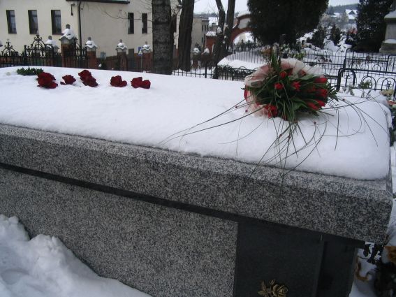 Kto uoy na pycie sarkofagu krzy z czerwonych r i zielony wianek oraz bukiet czerwonych tulipanw